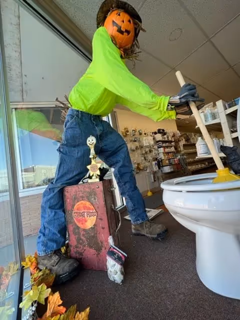 Technician using a portable drain auger machine to clear a clog.