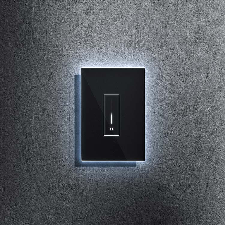 A black and white light switch with a blue light shining on it.