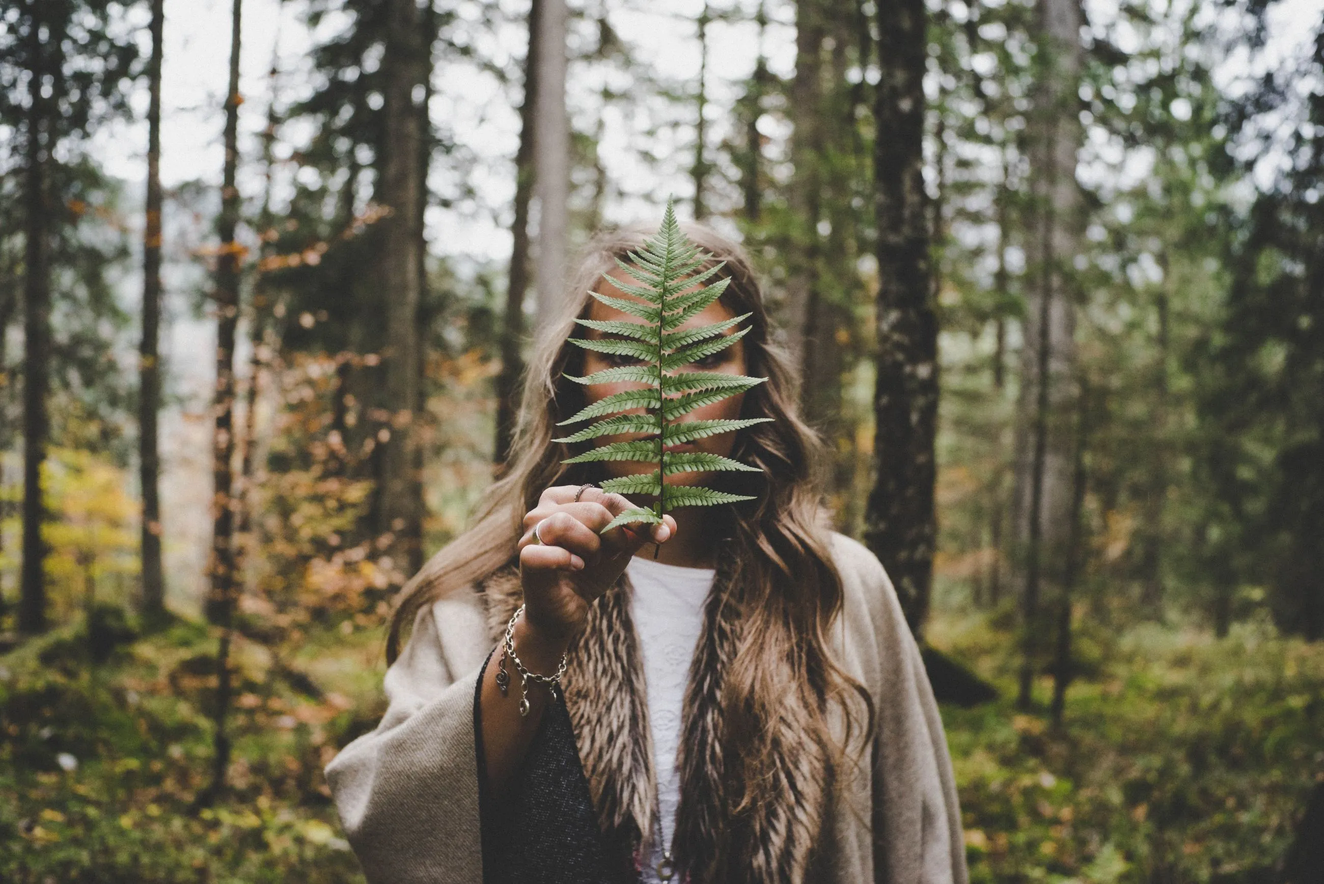 Woman holding a leaf in the woods