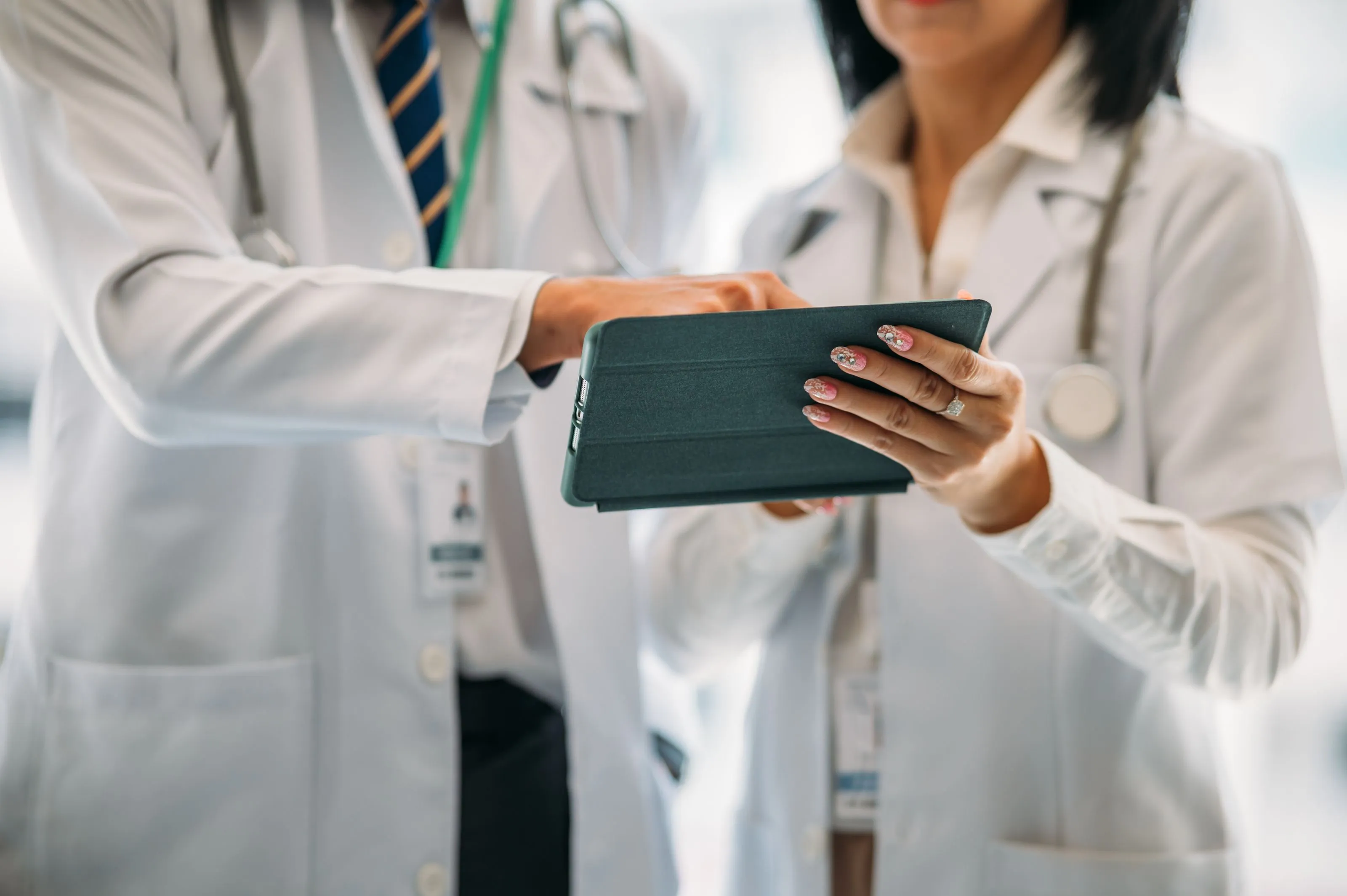 Two doctors looking at a handheld tablet