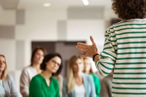 Womens standing up facing other women talking 