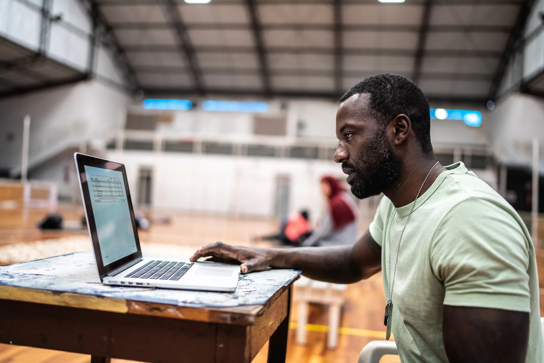 Black man sitting at a desk working on a laptop computer
