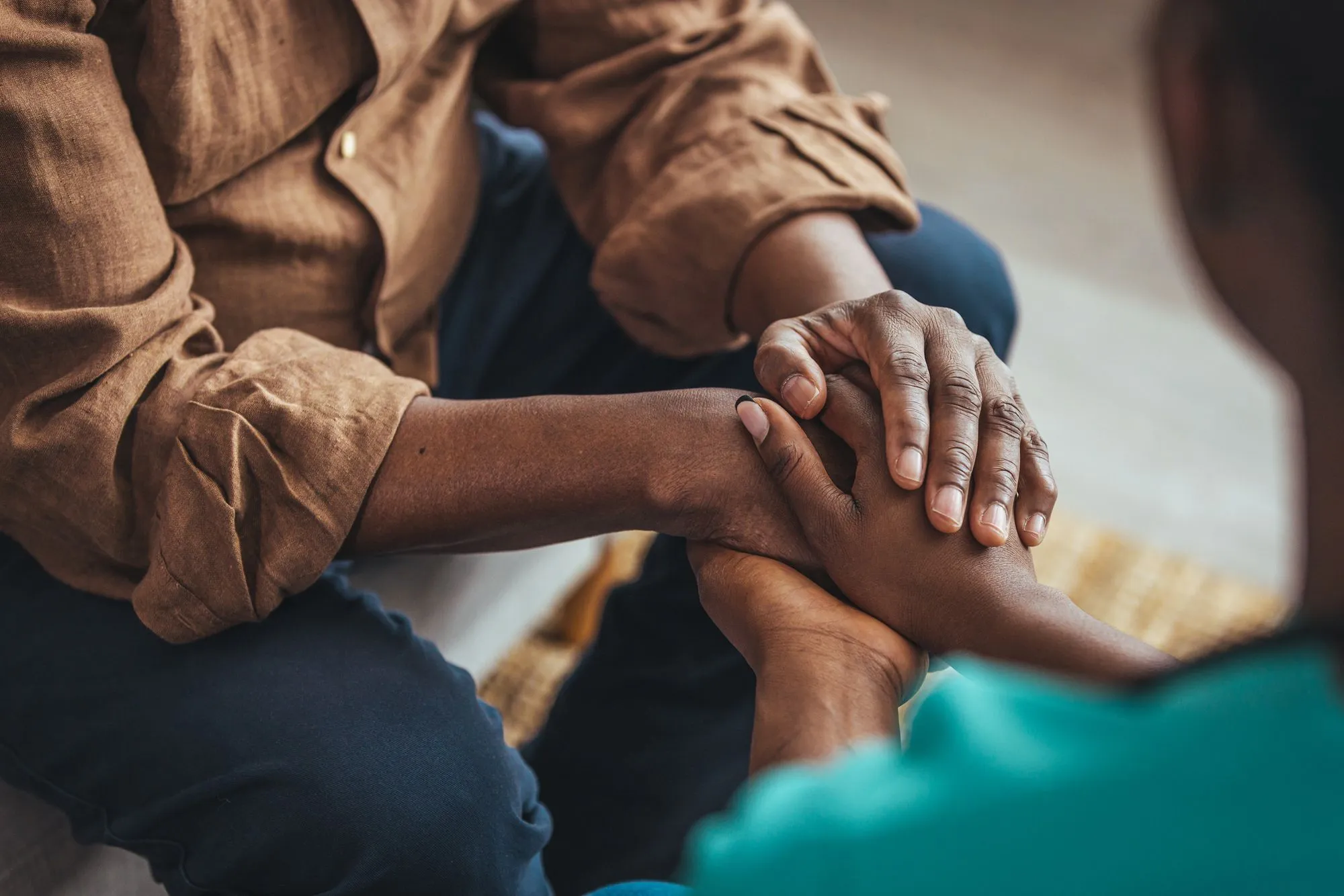 Two sets of black hands holding one another