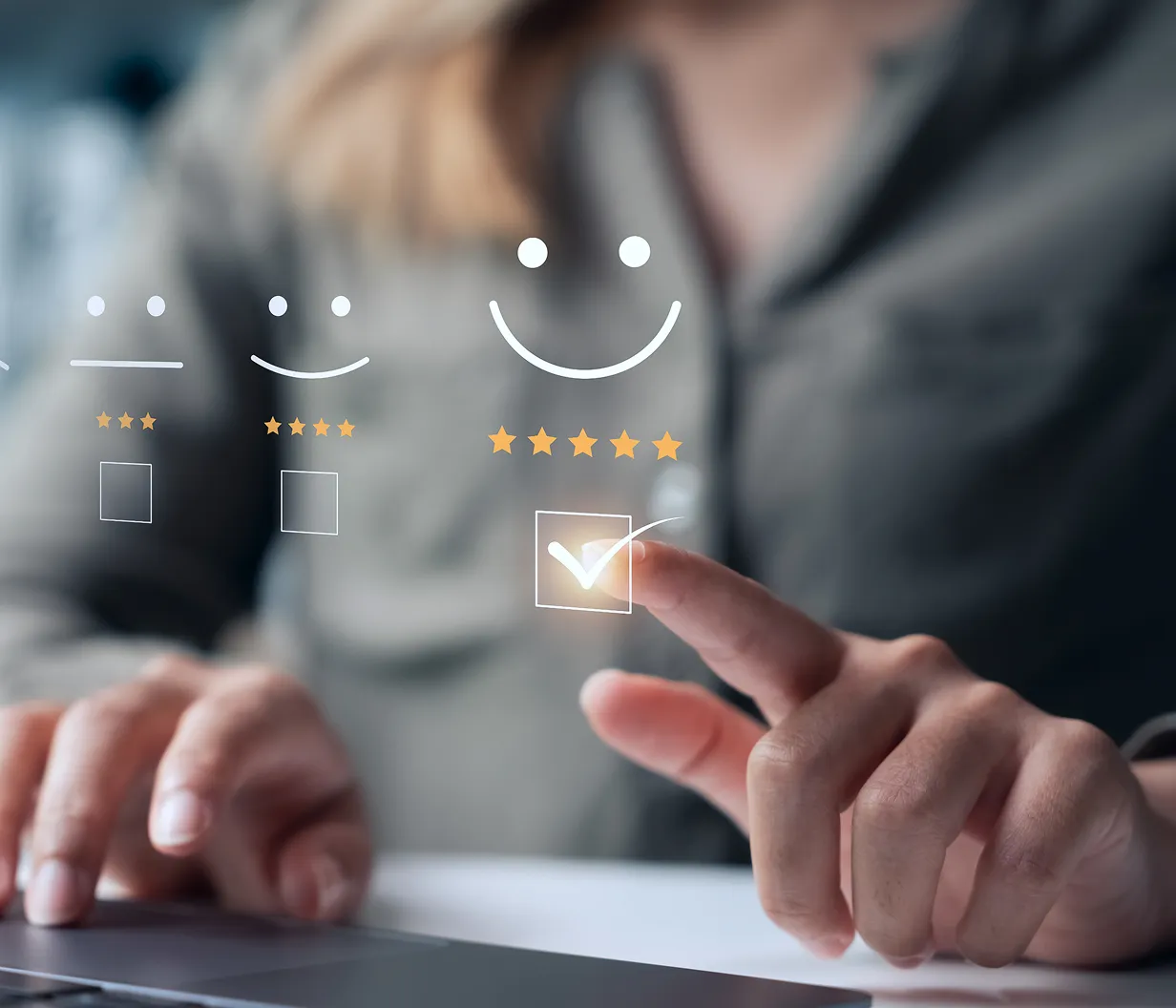 Person selecting a five-star satisfaction rating on a digital interface with smiley face icons, representing customer feedback or quality assurance.