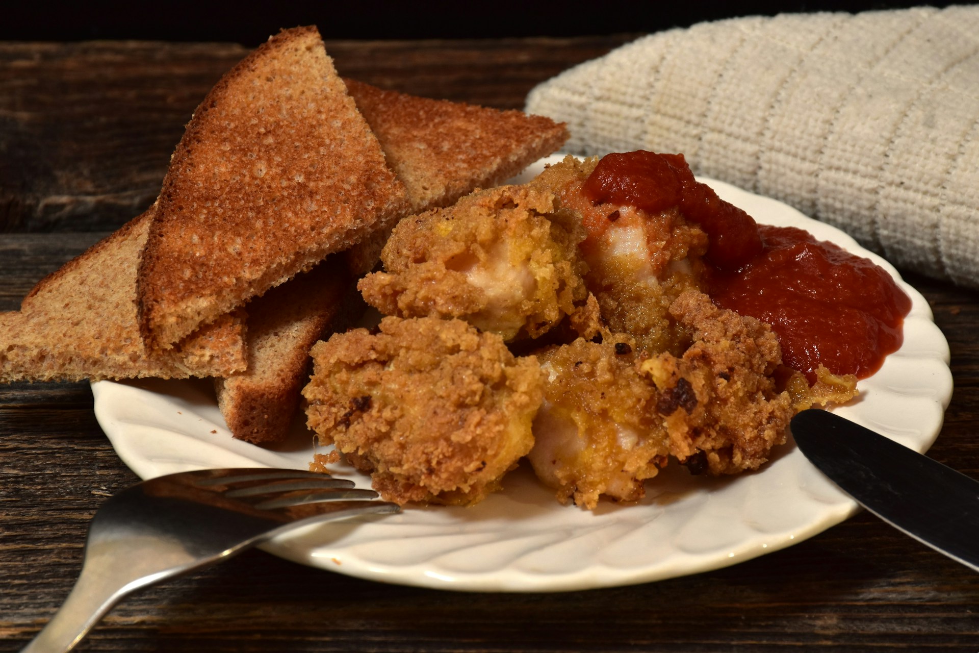 A plate featuring a slice of bread alongside pieces of fried chicken