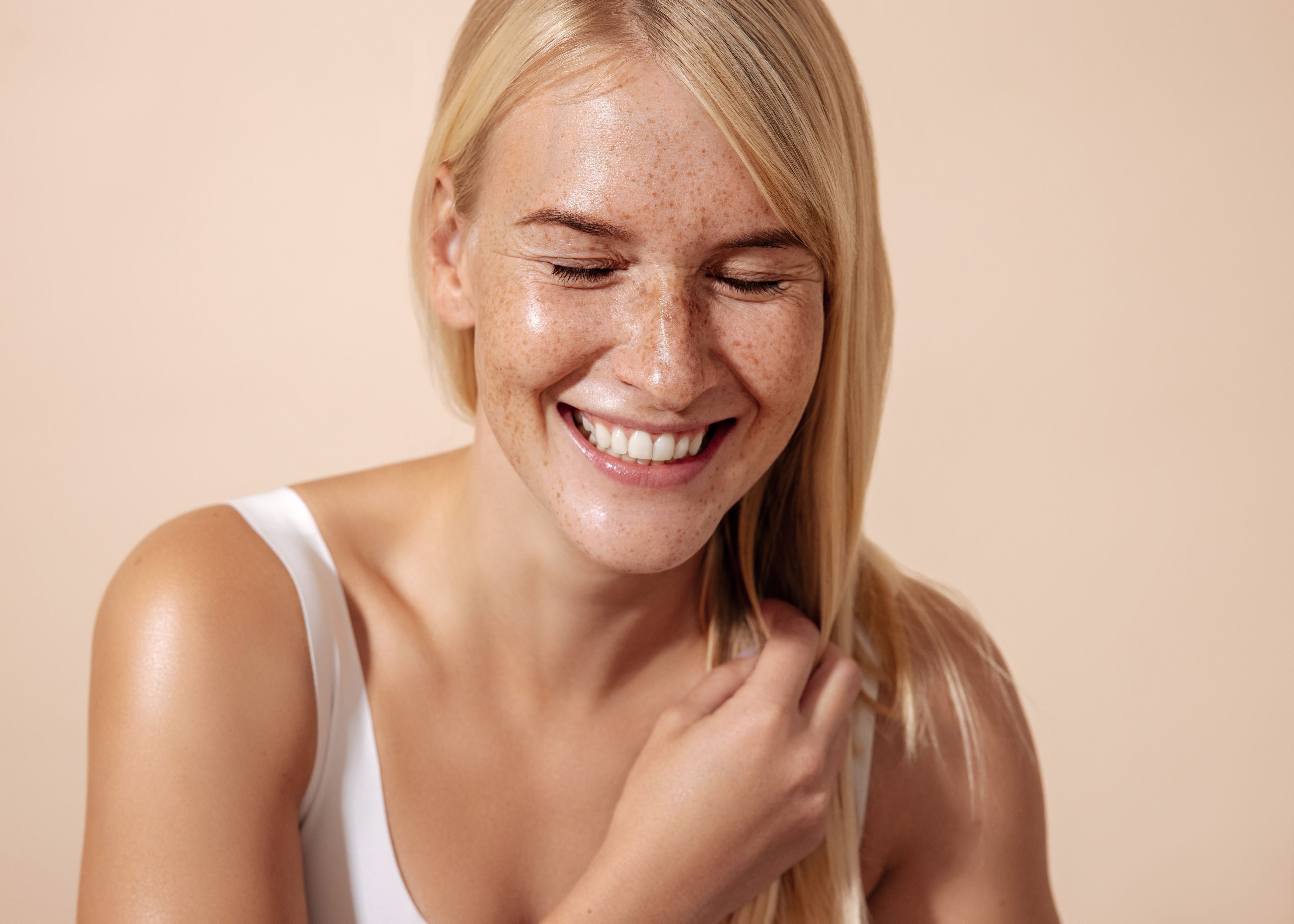 A woman smiles as she brushes her hair.