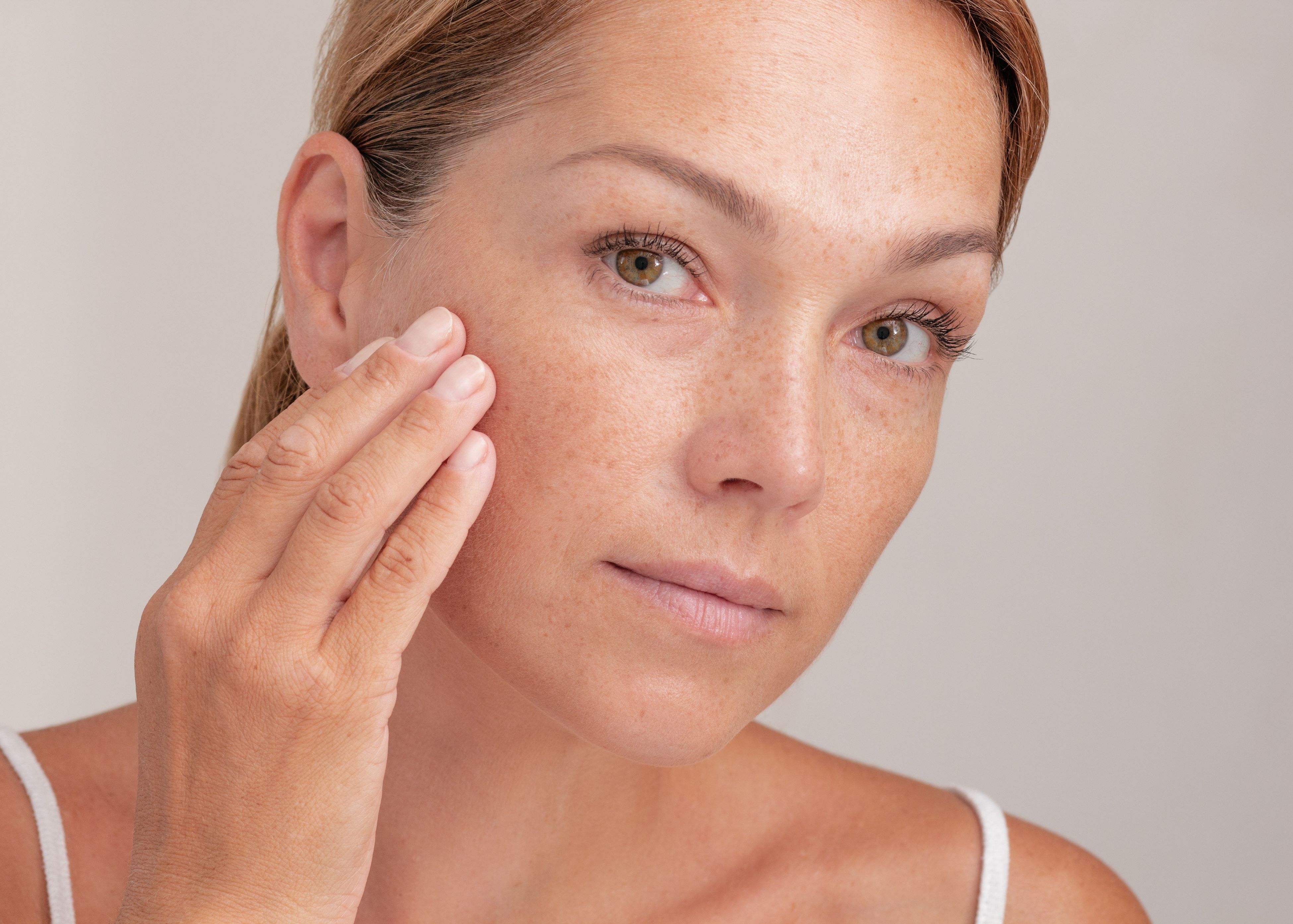 A woman holding her hand to her face.