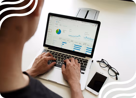 Man looking at computer screen showing charts and data