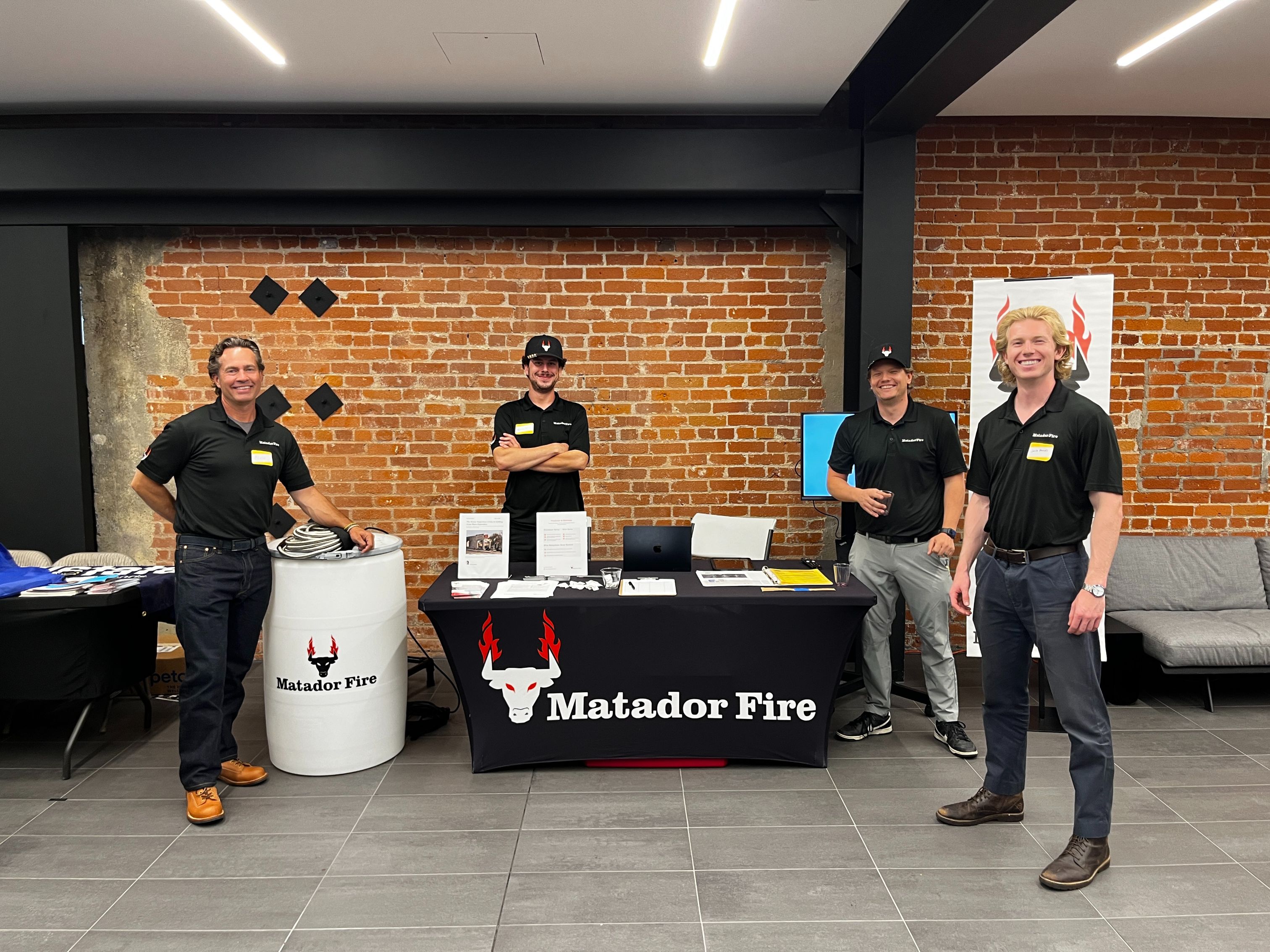 The Matador Fire team around a booth at a non-profit event for Palisades Dolphin Strong