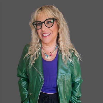 Nancy A. Shenker smiles wearing glasses and a green leather jacket