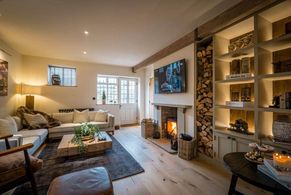 Living room with wood burner, built-in shelves and log storage