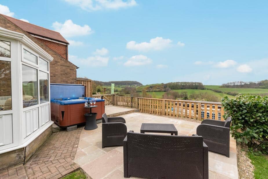 Cottage patio with seating area and hot tub overlooking countryside views