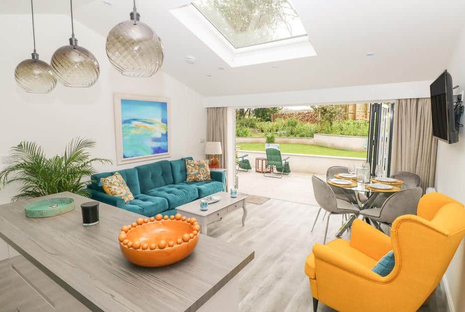Cottage living area with skylight, open patio doors, and lounge seating