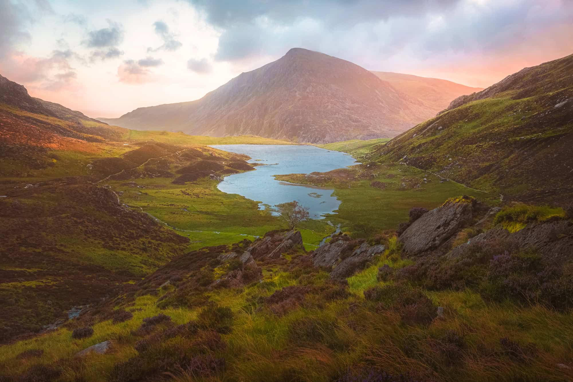 A breathtaking sunrise over the misty Cwm Idwal valley and Llyn Idwal lake