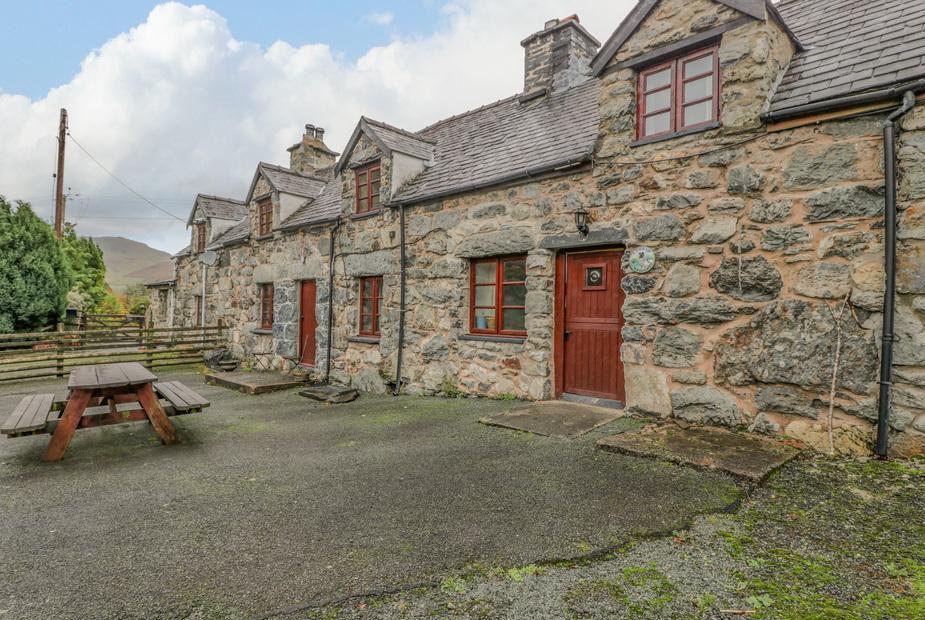 Stone-fronted Ysgubor with picnic bench on paved patio area