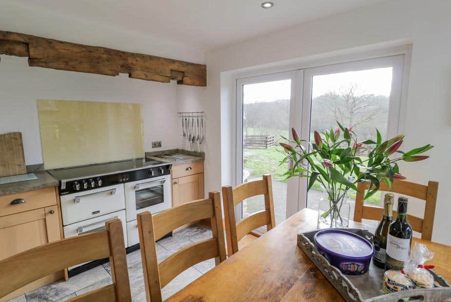 Cottage kitchen with range cooker and dining table by patio doors