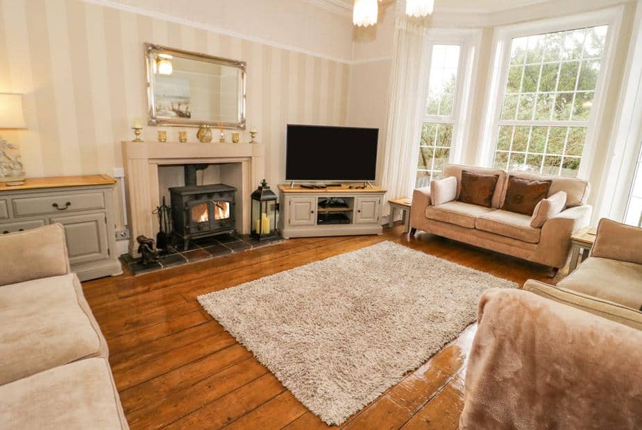 Living room with wood burner, sofas and bay window