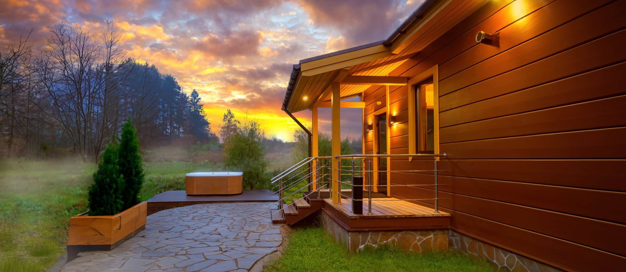 Serene hot tub escape at a modern English cabin during a golden hour sunset.