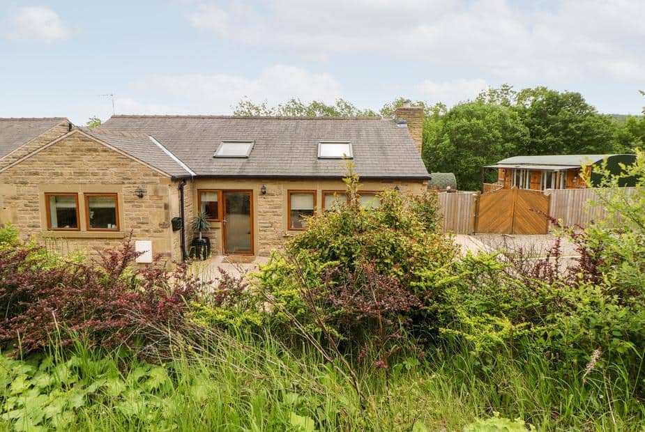 2 Pheasant Lane stone cottage with skylights and garden shrubs in the foreground