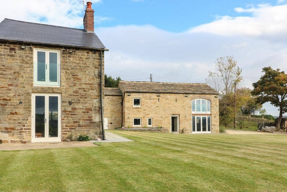Top Hill Farm Cottage with large stone exterior and spacious lawn