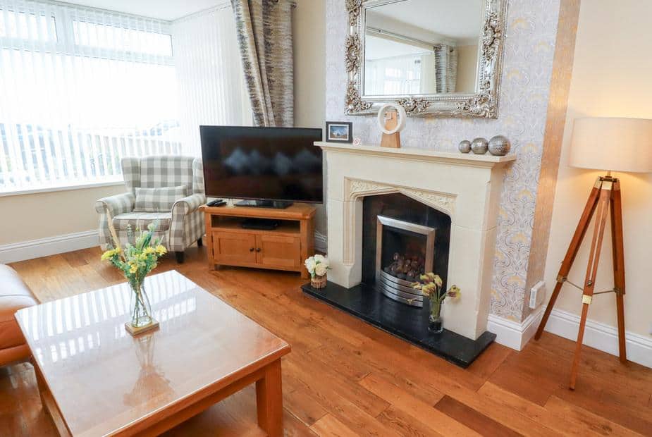 Cottage living room with fireplace, television, armchair and wooden coffee table