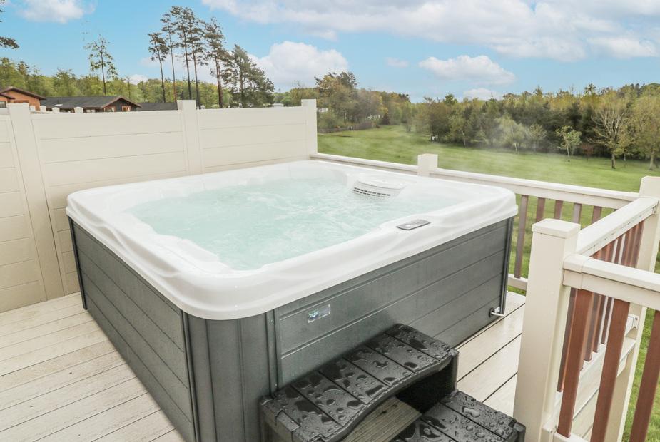 Lodge deck with hot tub overlooking grassy area