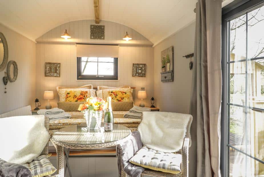 Lodge interior with double bed and small dining table by window