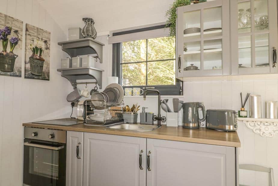 Lodge kitchen with oven, sink and grey cabinets under window