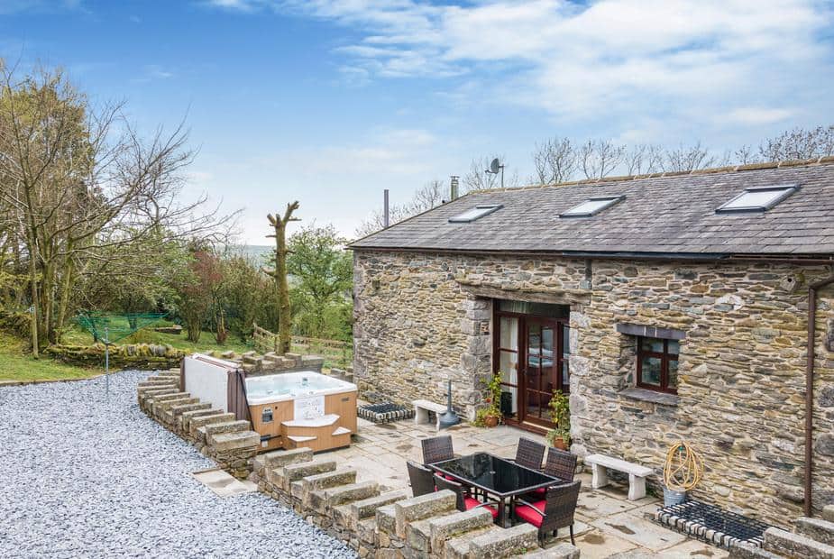 Hill Side Barn stone cottage exterior with patio seating and outdoor hot tub