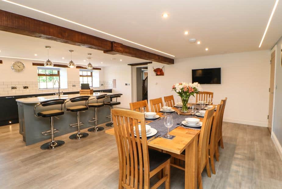 Cottage kitchen and dining area with wooden table and breakfast bar with stools