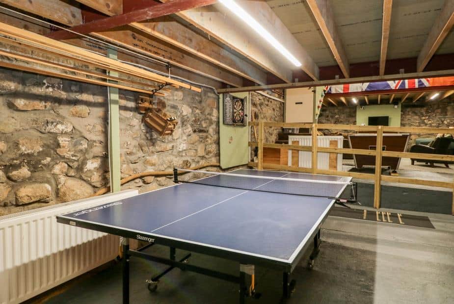 Cottage games room with table tennis table and dartboard