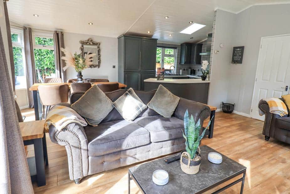 Lodge living area with grey sofa and coffee table facing open kitchen and dining table