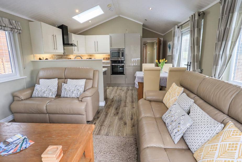 Lodge living area with two sofas, coffee table and open-plan kitchen in background