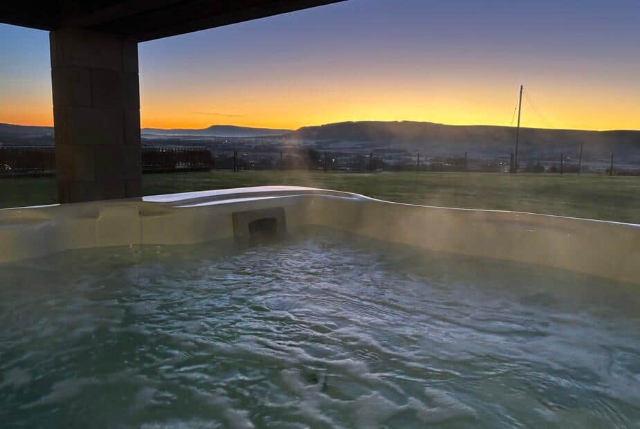 Cottage garden with hot tub overlooking fields at sunset