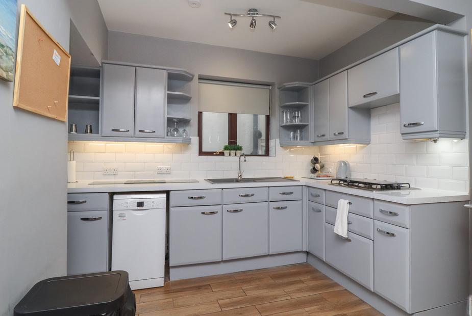 Cottage kitchen with grey cabinets, gas hob and built-in dishwasher