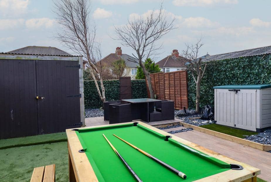 Cottage garden with pool table, outdoor seating, shed and storage unit