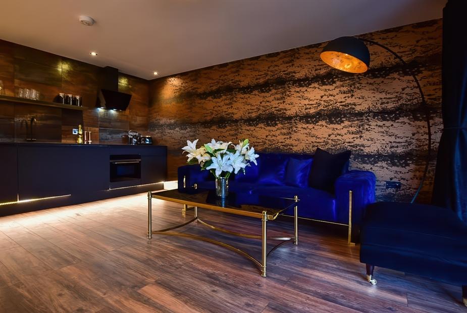 Lodge living area with blue sofa, glass coffee table and open kitchenette