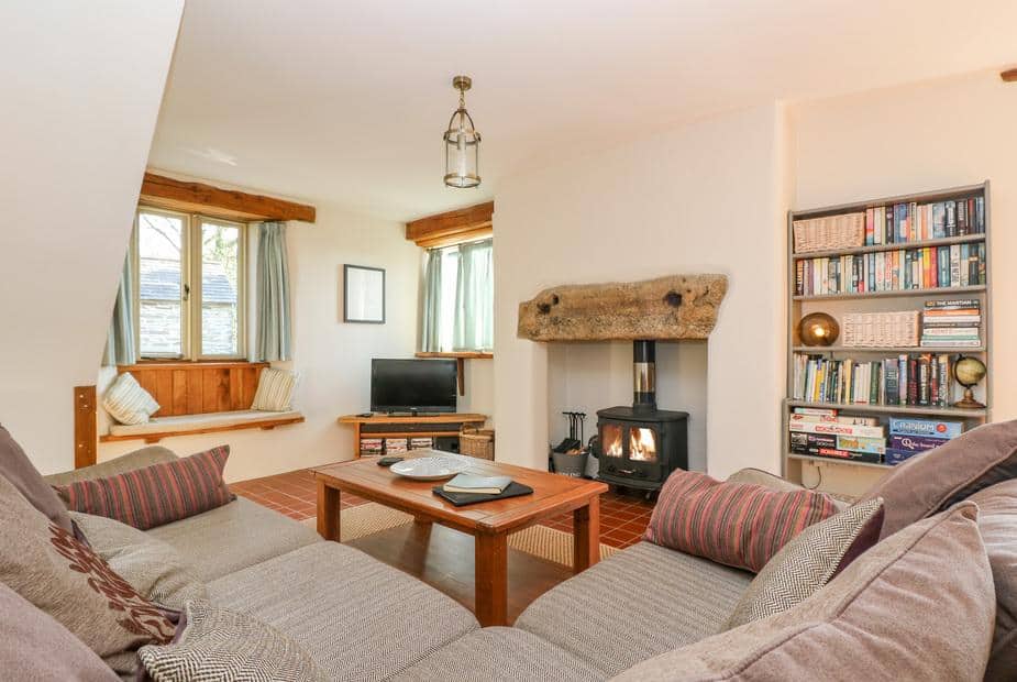 Cottage lounge with wood-burning stove, bookshelves and window seat