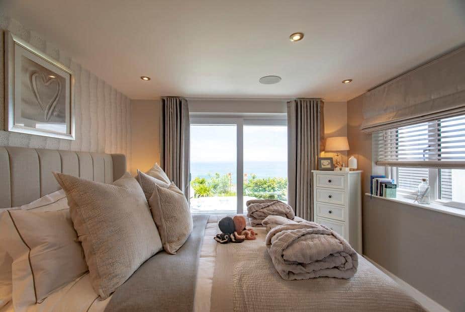 Cottage bedroom with double bed and sea view through large window