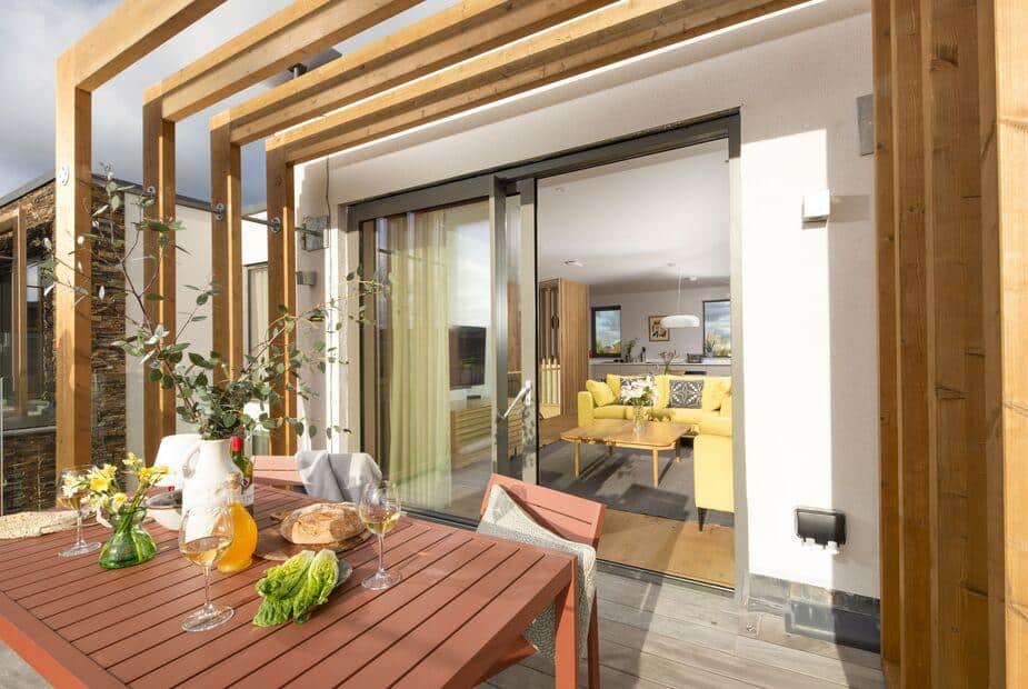 Lodge patio with outdoor dining table, view into living room through sliding glass doors