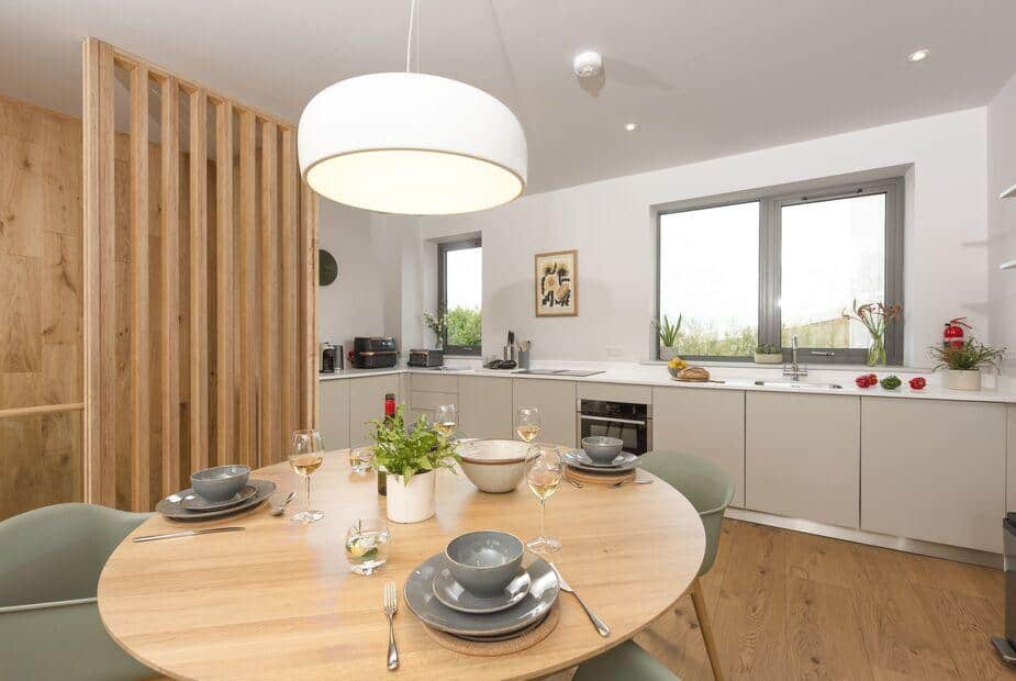 Lodge kitchen with round dining table set for four and modern light fitting above