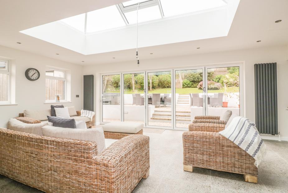 Cottage lounge with wicker sofas and glass doors opening to patio with seating