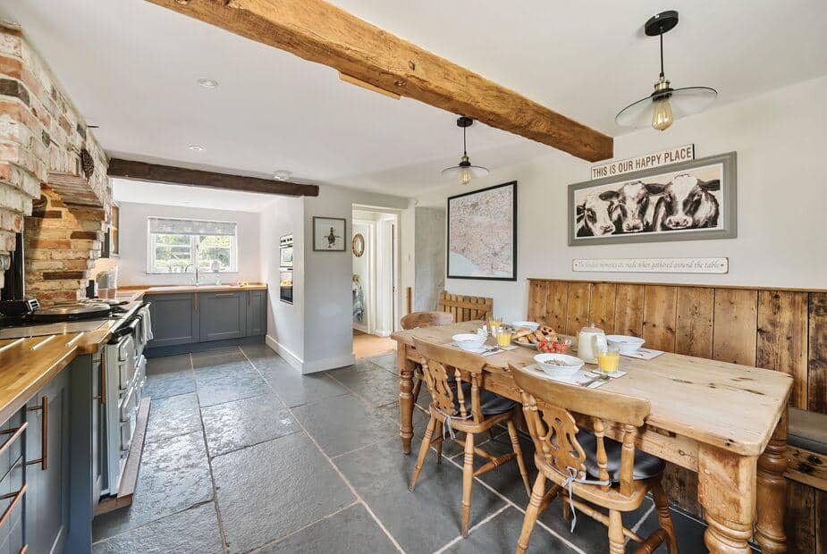 Cottage kitchen with wooden dining table and exposed ceiling beams