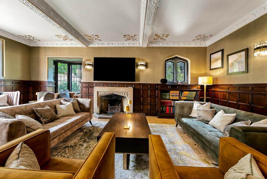 Cottage living room with beamed ceiling, fireplace, sofas, and bookshelves