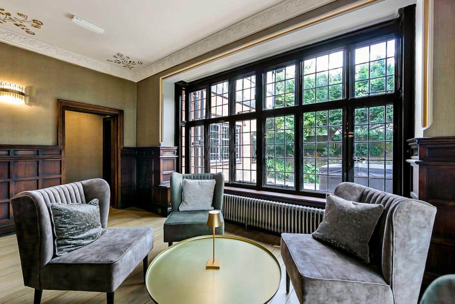 Cottage sitting area with three chairs and large leaded window