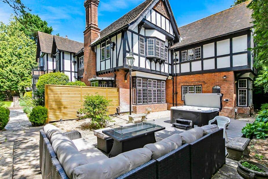 Cottage garden patio with rattan sofa set and hot tub