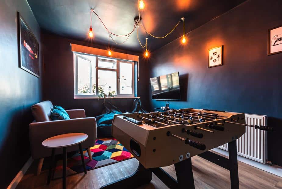Cottage games room with table football, sofa and wall-mounted TV