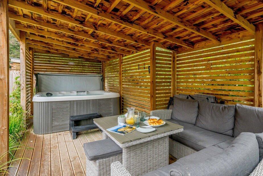 Covered patio with hot tub and outdoor seating area