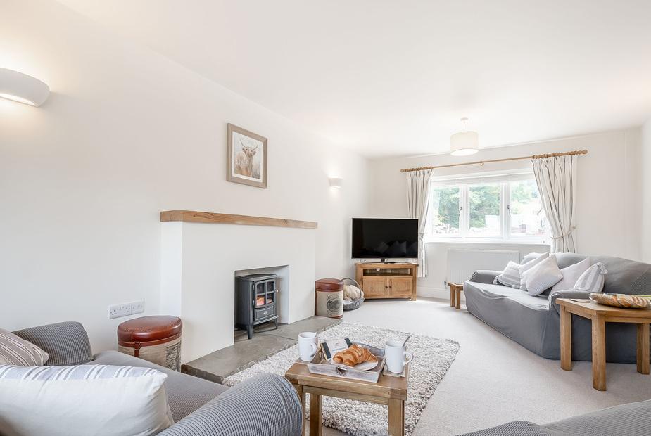 Cottage living room with wood burner, sofas and television
