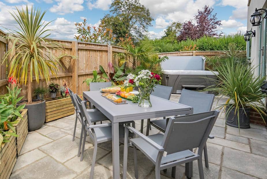 Cottage patio with dining set, potted plants and hot tub